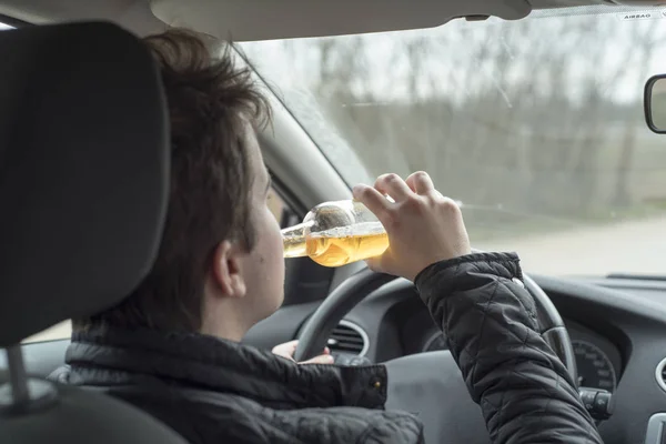 Ung man kör sin bil när man dricker alkohol — Stockfoto