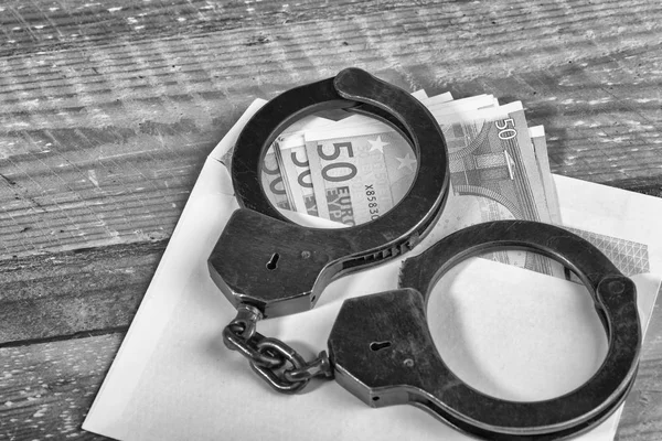 Handschellen und Euro-Scheine — Stockfoto
