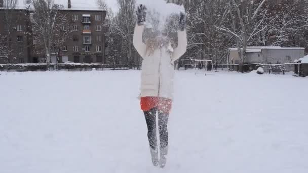 Szczęśliwa dziewczyna przeskakując nad niebieskim tle niebo i śnieg — Wideo stockowe