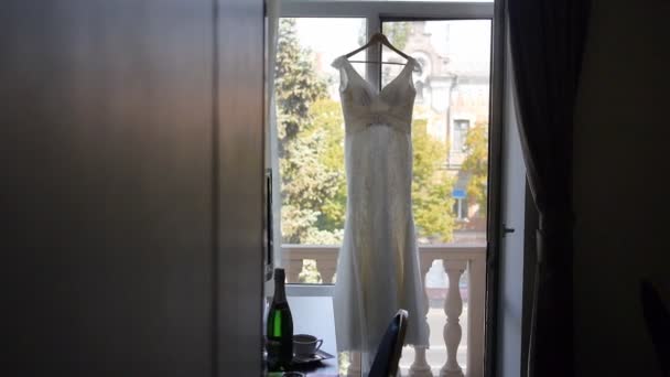 Wedding dress hanging in a window. — Stock Video