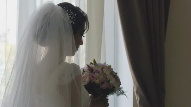 Silhouette de mariée à côté de la fenêtre avec son bouquet de mariage — Video