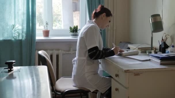 Medical doctor in the office at the table. doctor in a very old hospital in the office — Stock Video