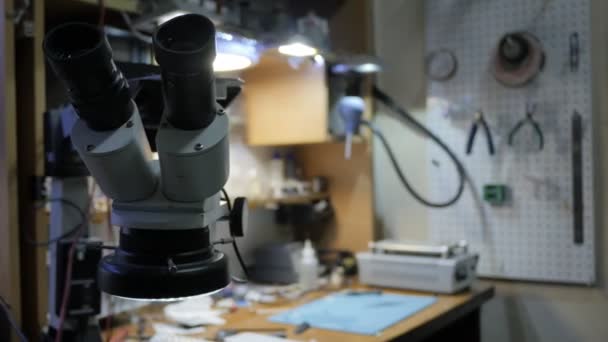 Микроскоп в мастерской по ремонту электроники — стоковое видео