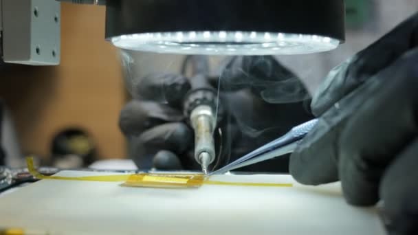 Electrónica de soldadura. Soldar las partes dañadas del teléfono inteligente y el ordenador portátil. Soldadura de la placa al microscopio — Vídeo de stock