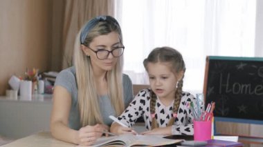 Evde eğitim. Anne ve kızı ders alıyor..