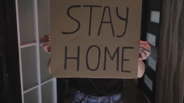 Aktivistin, junges Mädchen mit Maske im Gesicht und einem Poster Stay home, auf Karton — Stockvideo