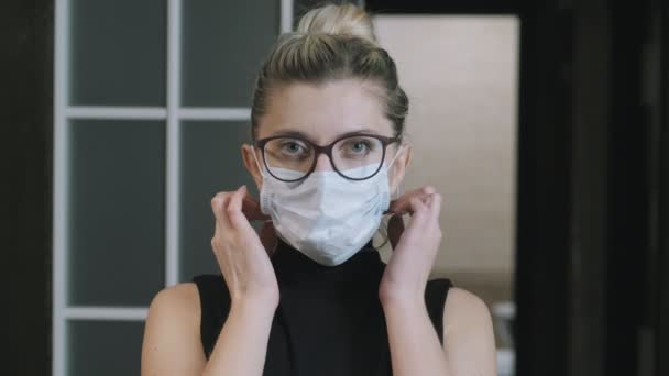 Fille, femme enlève masque de protection médicale prend une profonde respiration, regarde la caméra. Concept de quarantaine contre le coronavirus. La femme est enfermée. En quarantaine. masque facial — Video