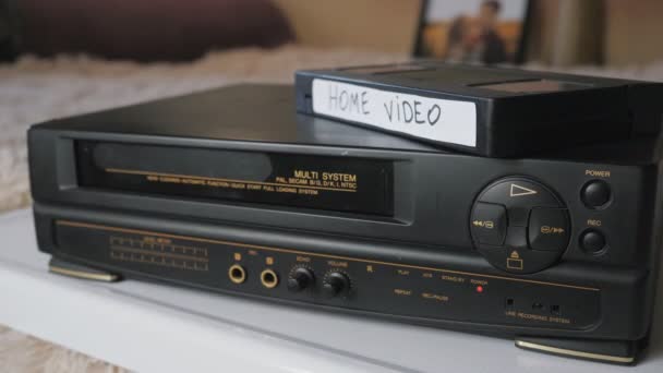 El casete de vídeo se carga en el VCR. Reproductor de vídeo negro vintage — Vídeo de stock