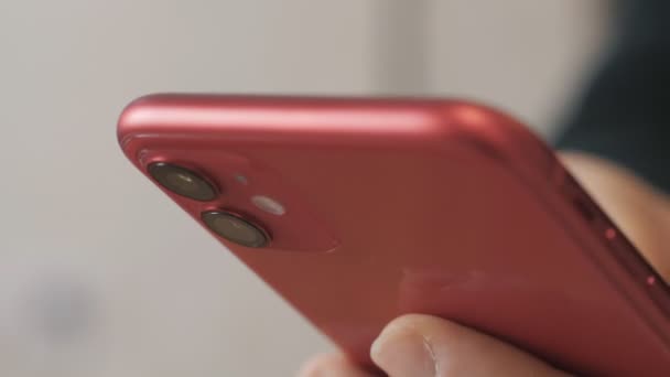 Mãos de um homem segurando um telefone, um telefone vermelho, um homem aponta um dedo para o close-up do telefone . — Vídeo de Stock