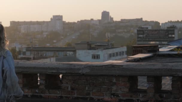 La joven corre en el techo de una casa antigua, saltando a través de bloques de hormigón.. — Vídeos de Stock