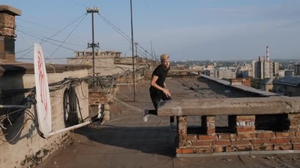 일몰 때 콘크리트 블록 위로 뛰어드는 파쿠 르, 집의 지붕느린 움직임 — 비디오