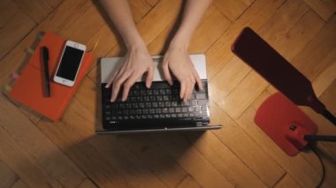 Bilgisayar klavyesine yoğun bir şekilde tuşlara basarak kod yazan bir hacker.
