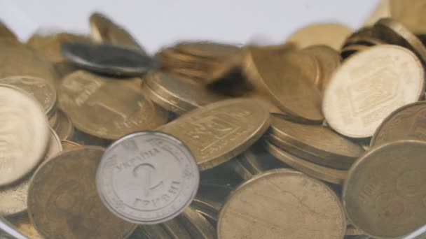 Valse metalen munten in een stapel, hryvnia munten vliegen in een spaarvarken bank. — Stockvideo