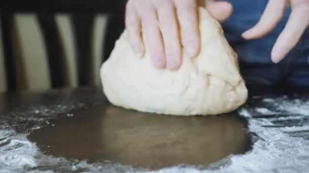 Бабки. Раскатайте дрожжевое тесто, чтобы сделать мясной пирог на деревянном столе. Крупный план . — стоковое видео