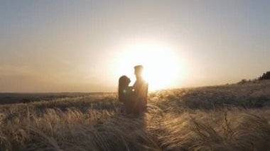 Birbirini seven çiftler birbirlerine bakıyor. Sevgili çift gün batımında.