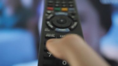 Uzaktan kumanda elinde. Evde televizyon izliyordum. Dinlen, evde boş zaman geçir..