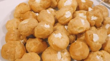 Profiterol kekleri. Yemek servisi. Kafede taze kremalı Fransız profiterolleri. .