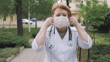 Sağlıkçı. Tıbbi Maskeli Doktor. Yüz maskesi tak. Koronavirüs salgını. Önlüklü hastane çalışanı yüzüne maske takıyor. Sağlık Koruması Corona Virüsü.