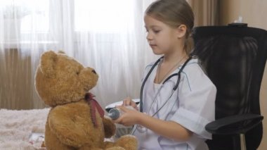 Doktorculuk, hemşire. Evde doktorculuk oynayan küçük bir kız Şırınga enjekte ediyor