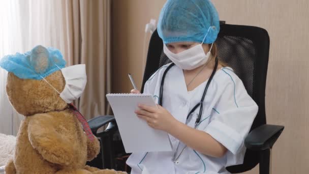 Mała Dziewczynka Masce Medycznej Bawiąca Się Doktora Pielęgniarka Domu Diagnoza — Wideo stockowe