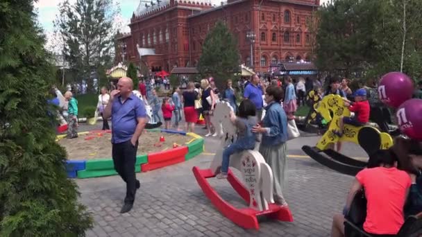 Niños montados en juguetes de balanceo en la Plaza Manezh en Moscú, Rusia — Vídeo de stock