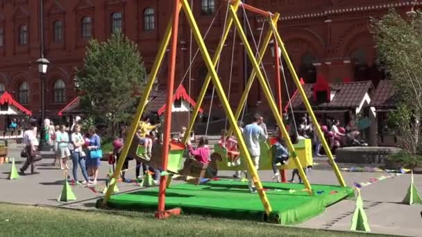 Niños balanceándose en un columpio gigante en la Plaza Manezh en Moscú, Rusia — Vídeos de Stock