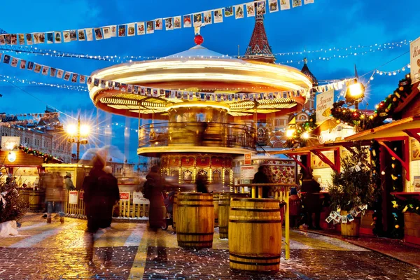 People on Christmas market on Red Square in Moscow city center, Decorated and illuminated Red Square for Christmas in Moscow. Carousel swings on Christmas bazaar — Stock Photo, Image