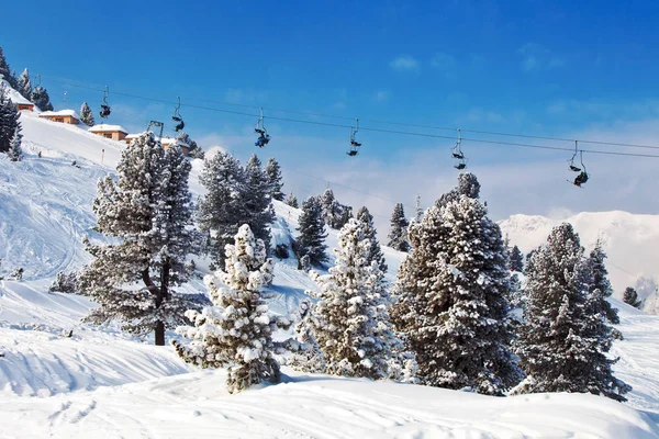 Sandalye kayak teleferiği ile dağlarda mavi gökyüzü üzerinde kayakçı — Stok fotoğraf