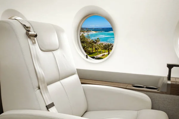 Sea and beach view in aircraft window, business jet flight — Stock Photo, Image