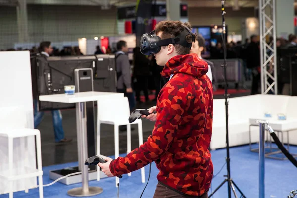 Man playing vídeo game in virtual reality headset and handheld controllers developed by HTC Vive on exhibition Cebit 2017 in Hannover Messe, Alemanha — Fotografia de Stock