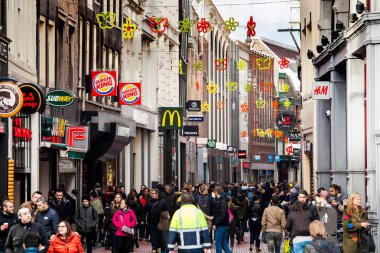 Kalabalık alışveriş caddesi birçok kişi ve dükkan işaretleri ile ünlü Nieuwendijk sokak Amsterdam, Hollanda