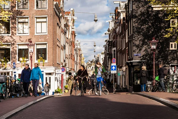 La gente del posto sulle biciclette sulla strada di Amsterdam. Giorno di primavera sotto la città — Foto Stock