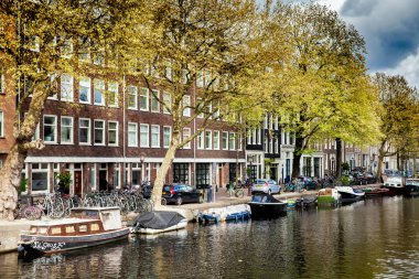 Amsterdam'da güneşli bahar günü. Kanal Manzaralı tekne ve Bisikletler, Hollanda