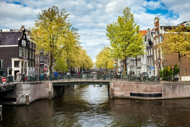 Amsterdam'da güneşli bahar günü. Kanal Manzaralı tekne ve Bisikletler, Hollanda