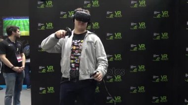 Htc Vive Vr kulaklık aksesuarları denetleyicisi olan sanal gerçeklik oyunu oynayan adam