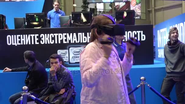 Girl playing virtual reality game in VR headset with accessories controllers on Intel stand — Stock Video