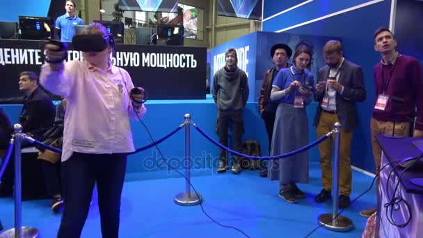 Girl playing virtual reality game in VR headset with accessories controllers on Intel stand — Stock Video