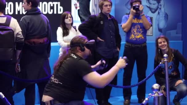Человек играет в игру виртуальной реальности в гарнитуре с аксессуарами на стенде Intel — стоковое видео