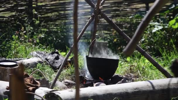 Preparación de la comida en olla sobre el fuego — Vídeos de Stock