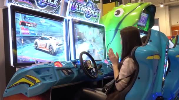 Chica jugando auto simulador videojuego arcade — Vídeo de stock