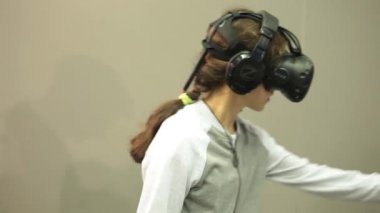Htc Vive Vr gözlüklü video oyunu oynayan kız.