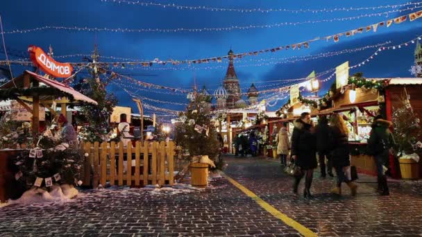 La gente en el mercado de Navidad en la Plaza Roja, decorado e iluminado para la Navidad en Moscú, Rusia — Vídeos de Stock