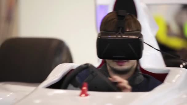 Mann benutzt Auto-Simulator mit virtueller Brille im Spielcenter — Stockvideo