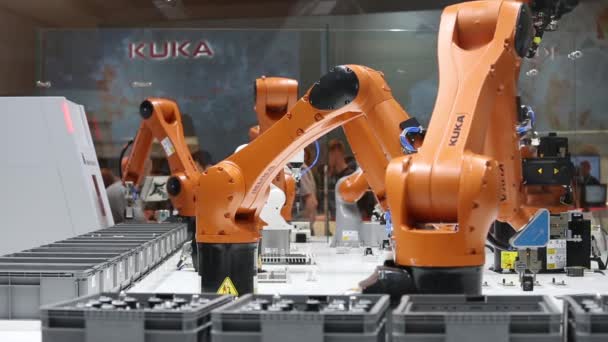 Soluciones de automatización del futuro con brazos robóticos en el stand de Kuka en la feria Messe en Hannover, Alemania — Vídeo de stock