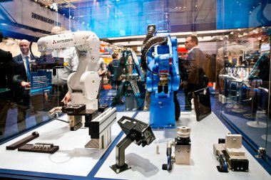 Mitsubishi and Yaskawa robot arms on Schunk stand on Messe fair in Hannover, Germany clipart