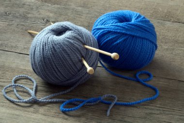 gri ve mavi ahşap bir masa iğne falan batmazdı örgü yün topları