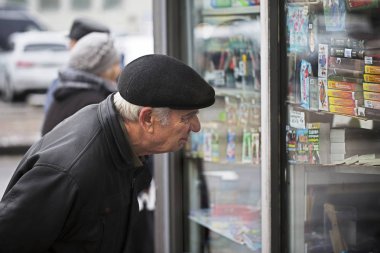 yaşlı adam bir vitrin inceliyor