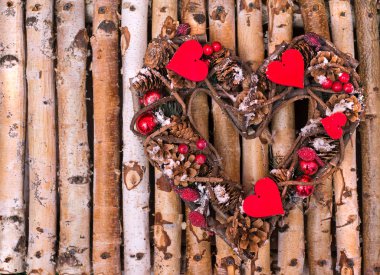 Koniler ve twigs ahşap çubukları üzerinde kalp şeklinde dekoratif çelenk