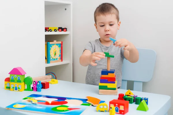 Le mani del bambino raccolgono puzzle di legno — Foto Stock