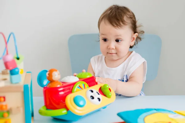 Küçük kız çocuk odasında eğitici oyuncaklarla oynuyor. — Stok fotoğraf